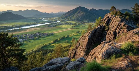 Panoramic vista of valley, town, river, and mountains at sunset