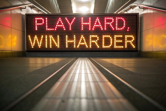 Neon sign with motivational phrase play hard win harder in a tunnel effect background