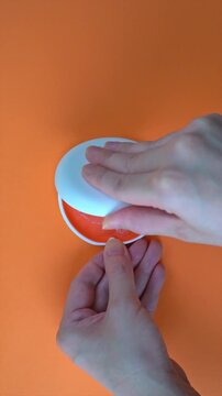 Opening White and Orange Dental Aligner Case that are  Orthodontic Mouthpiece storage in orange background. vertical video.