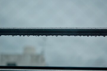 雨上がりの金属製の物干し竿についた滴る雨粒