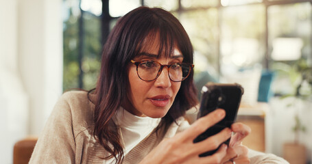 Home, woman and concerned with smartphone for scam or cybercrime on fake website. Mature person, sofa and annoyed at living room with internet or online fraud and hacking of social media profile