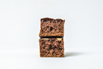 Pieces of brownies isolated on white background. chocolate. piece. peanuts. brown. homemade. dark. close up view. side. stack, pile. break, broken. half.