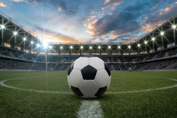 Soccer ball on green grass field in stadium with lights and crowd football sport
