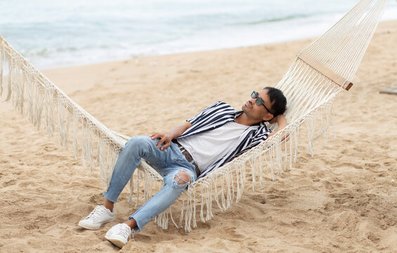 man relaxing on the beach with on hammock