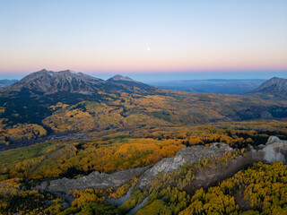 Aerial View of Colorado Mountain Valley Covered in Fall Colors | Autumn Landscape with Vibrant Yellow Aspen Trees, Scenic Horizon at Sunset, Seasonal September October Travel and Nature Background