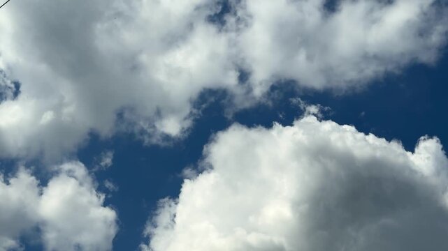 Clouds dance in the sky on a bright sunny day in mid afternoon