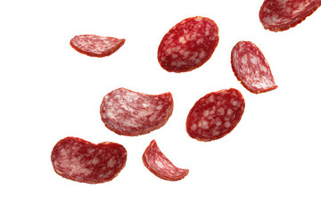 Slices of savory red salami scattered on a white background.