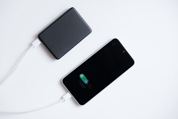 Portable powerbank for charging mobile phone battery with fast charging mode, isolated on white background.