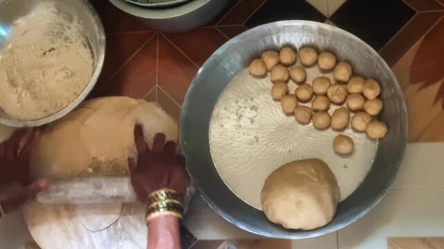 Crafting Indian flatbreads/sweets (Puri, Chapati, Modak): Begin by kneading dough, then form small balls, readying them for belan rolling and subsequent cooking in a kitchen setting.