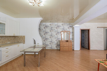 bright interior showcases a kitchen, dining area with a glass-top table, and a wooden dresser against a patterned wall