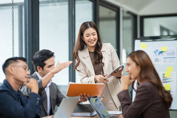 Group of Asian businesspeople sits down for a business investment planning meeting.	