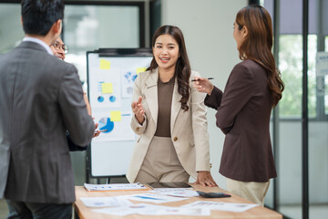 Group of Asian businesspeople sits down for a business investment planning meeting.	