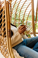 Relaxed woman taking a break, sitting in hanging chair.
