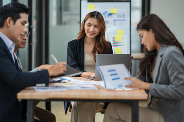 Group of Asian businesspeople sits down for a business investment planning meeting.