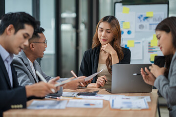 Group of Asian businesspeople sits down for a business investment planning meeting.