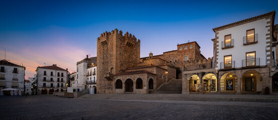 Fototapeta premium Vista panorámica del casco histórico de la ciudad española de Cáceres con vistas a los tejados de tejas marrones de edificios antiguos alrededor de la plaza principal en el soleado día de verano