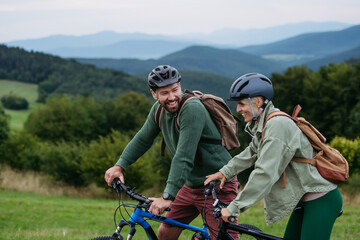 Couple cycling together in nature, smiling and enjoying outdoor adventure.