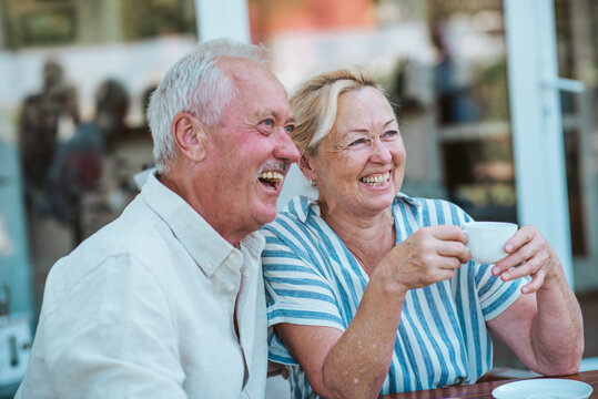 Smiling elderly couple enjoying coffee together in the garden. - Powered by Adobe