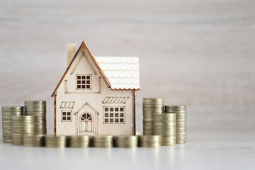 Mortgage,Model house and stack of coins money on wooden background,Business investment and real estate concept