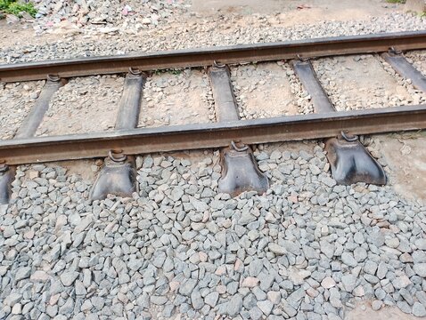 Close-up of parallel railroad tracks with ballast and weathered wooden sleepers