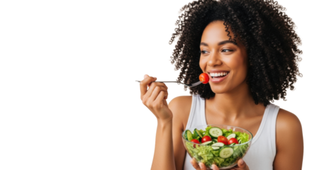African american woman, smiling, holding vibrant green salad, bringing fork with cherry tomato to mouth, light beige studio background with copy space left, healthy eating concept