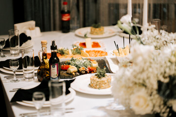 Elegant dining setup featuring gourmet dishes and floral arrangements at a celebratory gathering