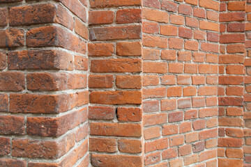 A brick wall with a red brick corner