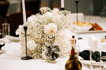 Elegant floral centerpiece adorns a dining table at a sophisticated event in an upscale venue