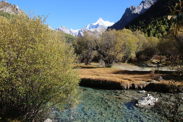 Majestic snow peaks tower over serene alpine rivers and lakes  Yading Nature Reserve, Sichuan, China