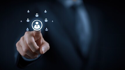 Businessperson's finger touches a glowing person icon, surrounded by smaller icons, on a dark background