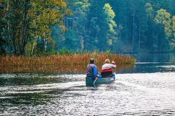 People are canoeing in a lake in autumn