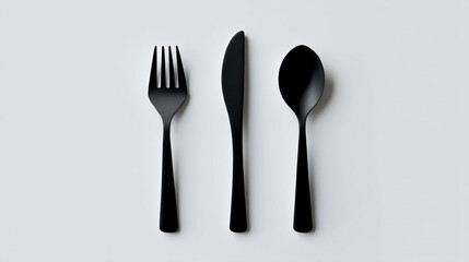 A minimalist flat lay of black fork knife and spoon on white surface