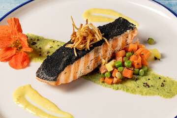 Grilled salmon fillet served with vegetables and gourmet garnish