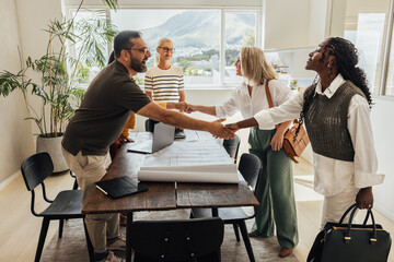 Architects greet clients with a firm handshake before a meeting.