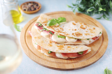Traditional Italian dish Piadina romagnola - flat bread with mozarella and proscuitto	
