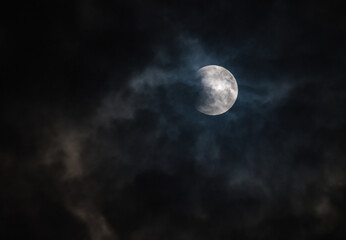 September's full moon, known as the Blood Moon, rises in the sky in Tehatta. As the eclipse begins, a wall of clouds rolls in and obscures the moon, creating various textures in the sky.