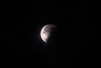 September's full moon, known as the Blood Moon, rises in the sky in Tehatta. As the eclipse begins, a wall of clouds rolls in and obscures the moon, creating various textures in the sky.