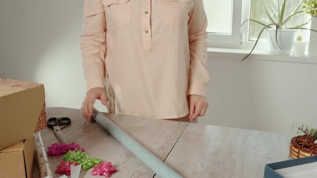 Woman rolling up wrapping paper for gift packaging