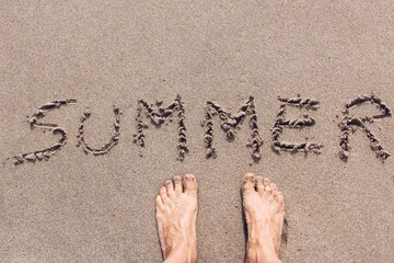 Sandy feet on a beach with the words 