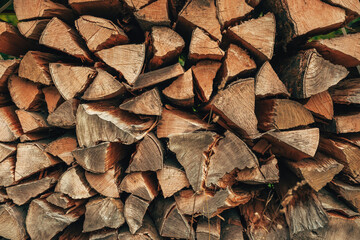 Neatly piled logs stored outdoors on a farm