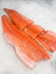 Fresh salmon fillets displayed on ice, showcasing vibrant orange color and intricate texture, ideal for culinary presentations and seafood dishes