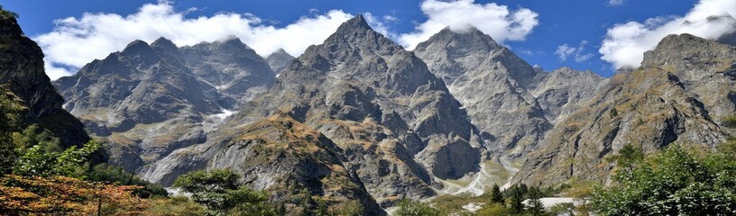 Naklejka premium Panoramic mountain range under a partly cloudy sky