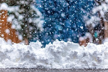 Snowy scene with snowdrifts, falling snow, and out-of-focus trees