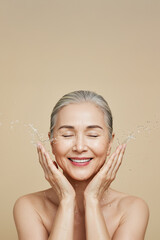 Senior Asian woman washing face for skin care and beauty routine with fresh water splash