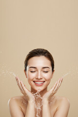 Young woman washing face for skin care and beauty routine with fresh water splash