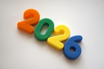 Fototapeta premium Colorful numbers forming 2026 on a white background with copy space.