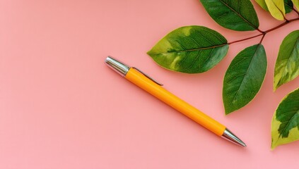Pastel pink background with yellow pen and leaves