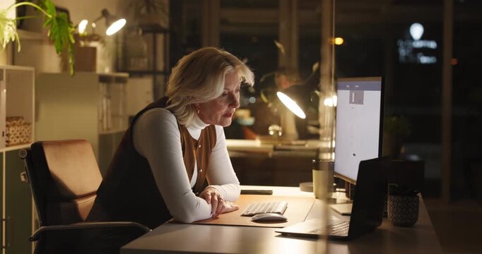 Burnout, night or mature woman in office with computer, stress and headache in bookkeeping. Tired, financial advisor or frustrated in career with technology, work deadline or fatigue in business.