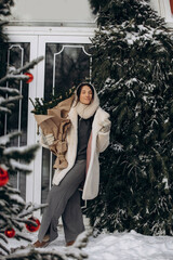 Obraz premium A woman walks along a city street on Christmas Eve in search of gifts and a good mood