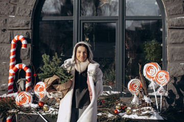 A woman walks along a city street on Christmas Eve in search of gifts and a good mood
